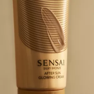Close up of Silky Bronze After Sun Glowing Cream bottle with swatch of it on top 
